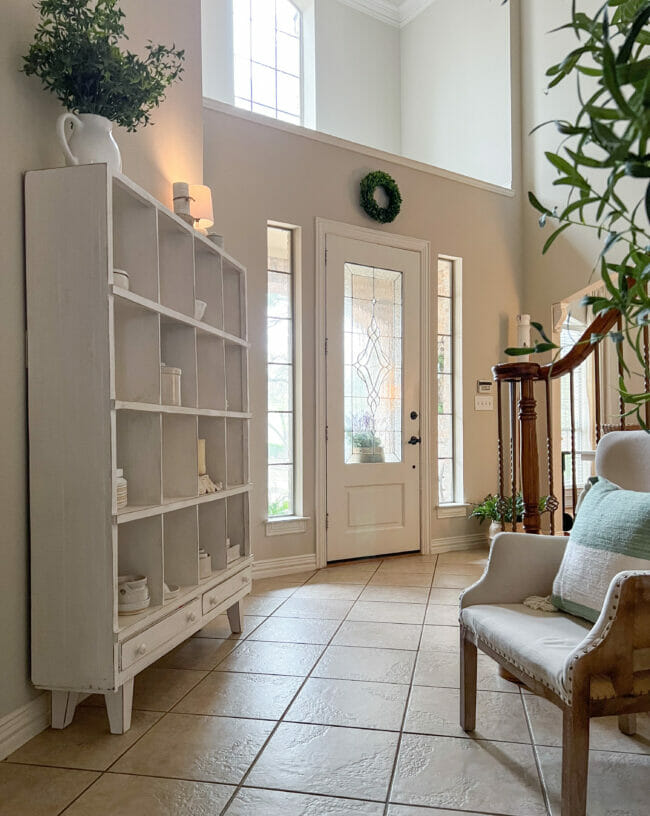 white cubby shelf with chair and front door