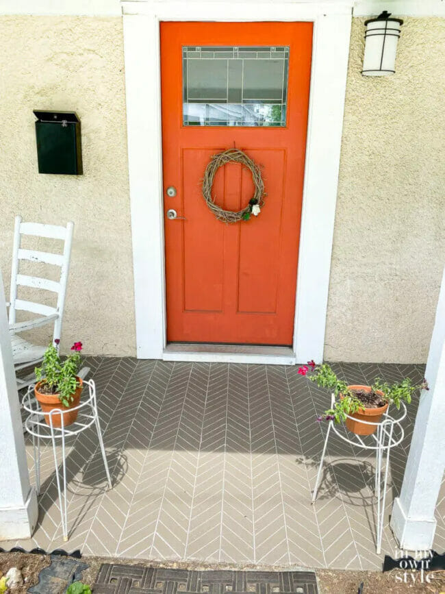 orange front door and painted porch with plants