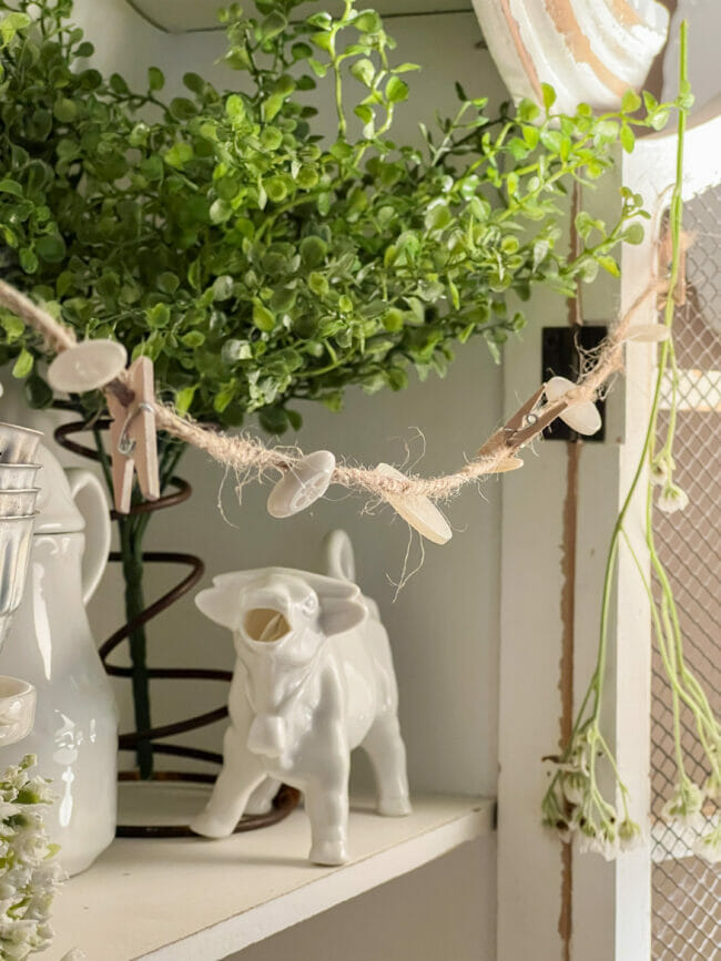 button garland with cow creamer and green stems