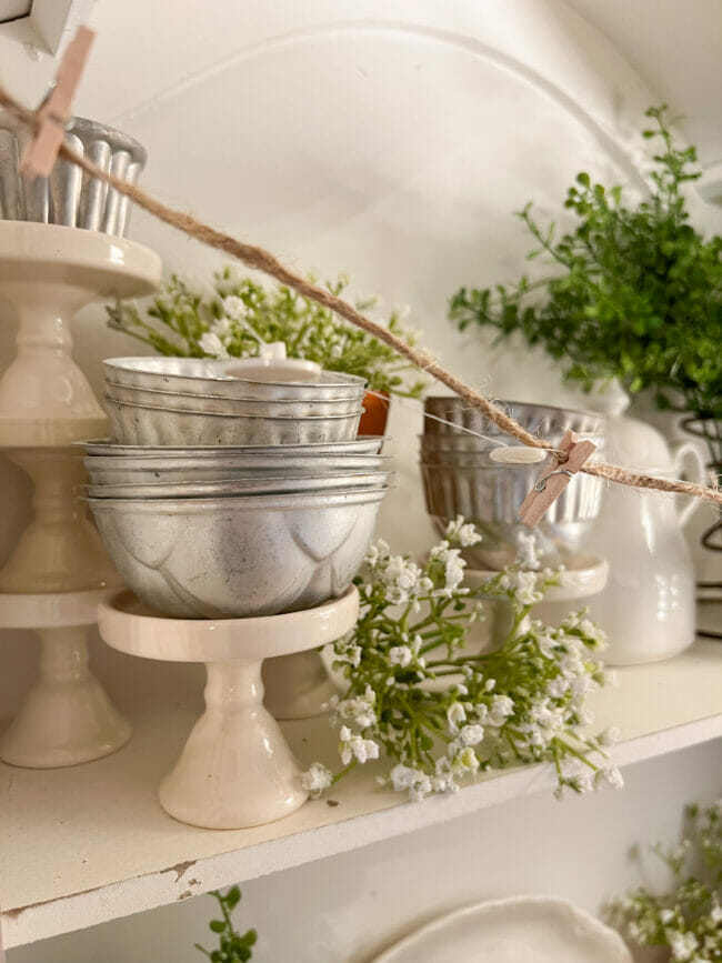 old tins sitting on cupcake stand with white flowers