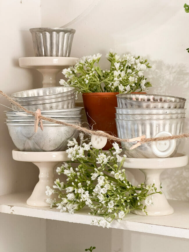 vintage tins on cupcake stands with white flowers