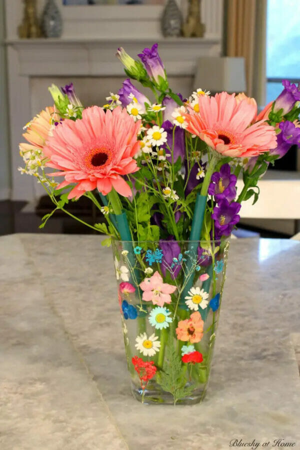 pressed flowers on glass vase with bright colored flowers