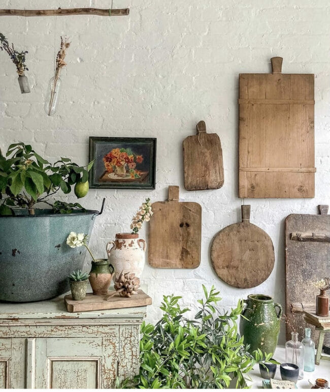 bread boards hanging on wall with plants