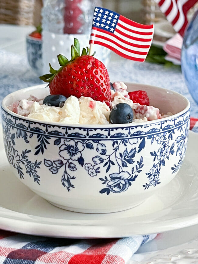 blue and white bowl with fruit salad and mini flag