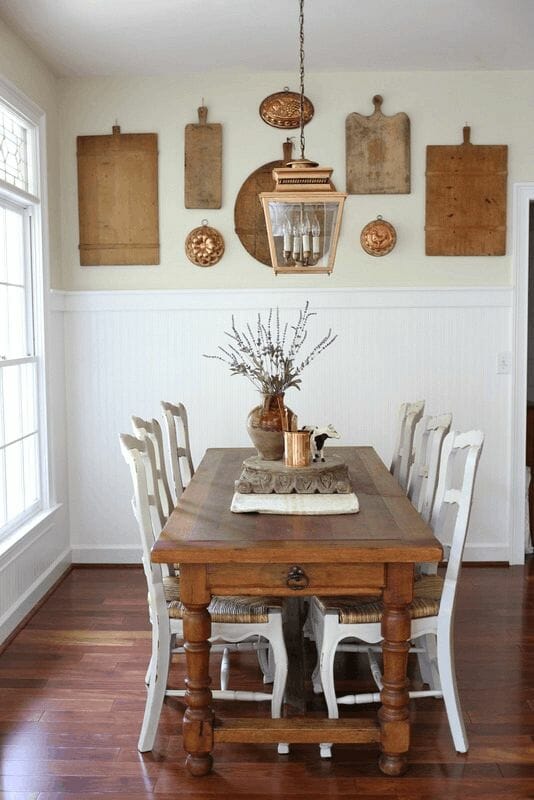 kitchen table with vintage breadboards hanging on wall