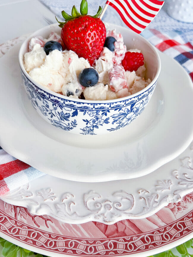 red, white and blue dishes with a bowl of fruit salad