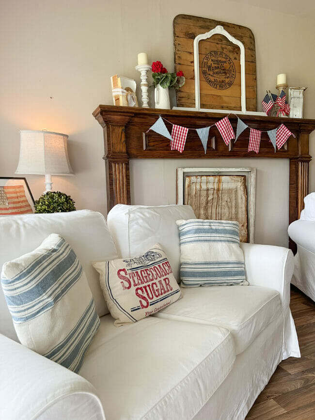 sofa with patriotic pillows and mantel with flag garland