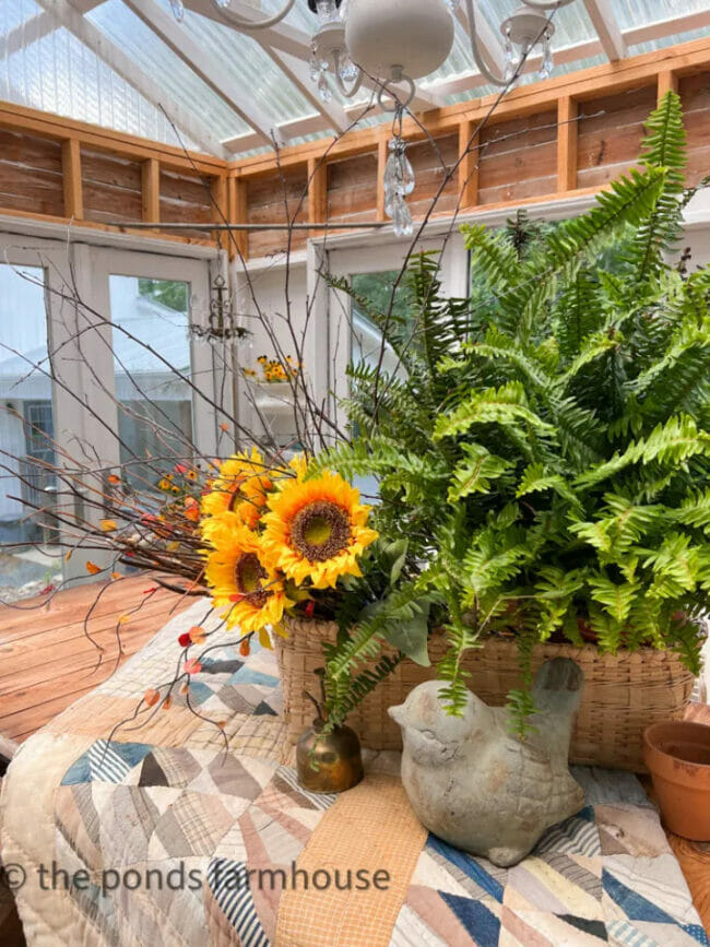 basket with fern and sunflowers and quilt as table centerpiece