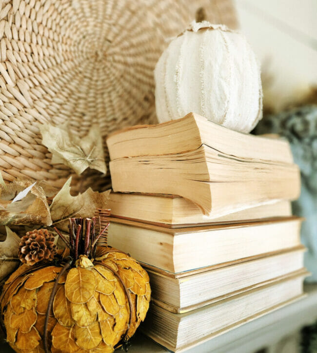 stacked books with white and gold leafy pumpkins