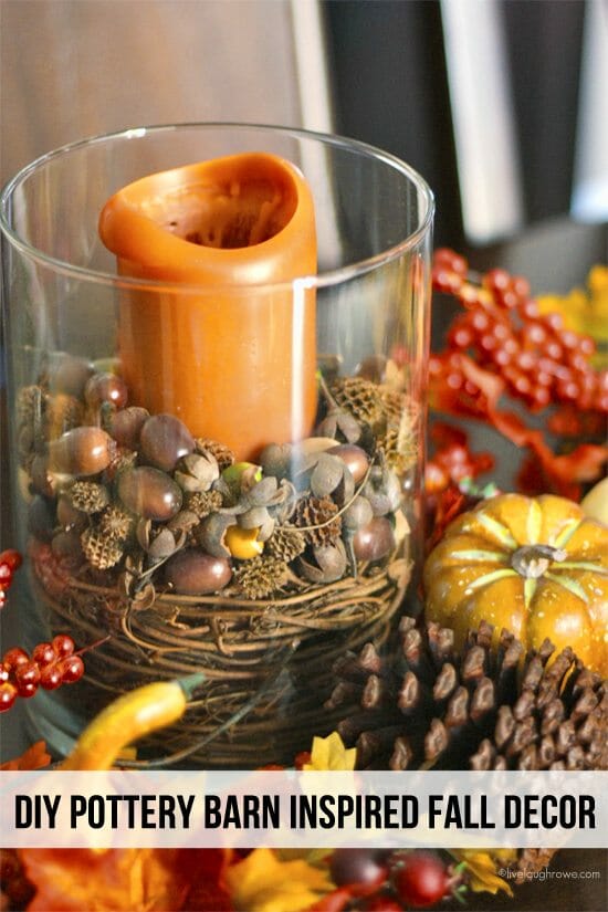 glass vase with acorns, pumpkins and orange candle