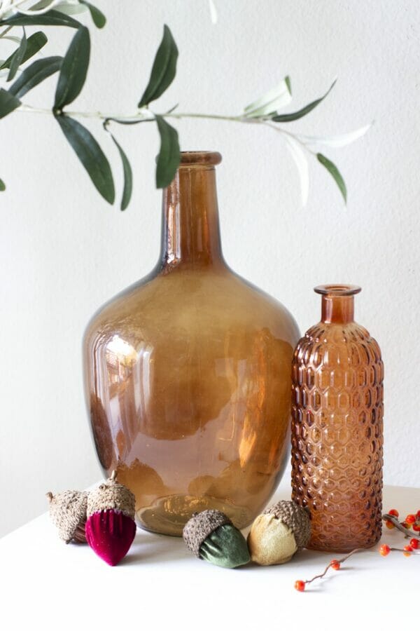 amber bottles with velvet acorns on table