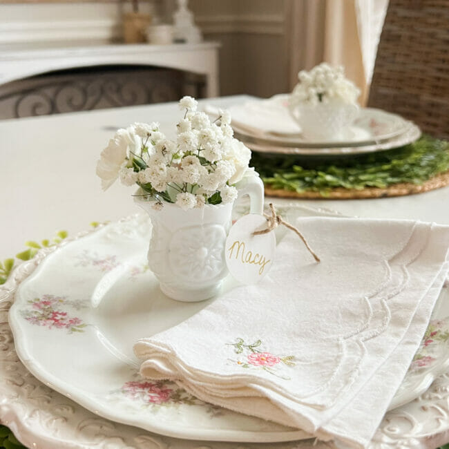 pink and white place setting with tiny milk glass creamer as a personal vase and place card.