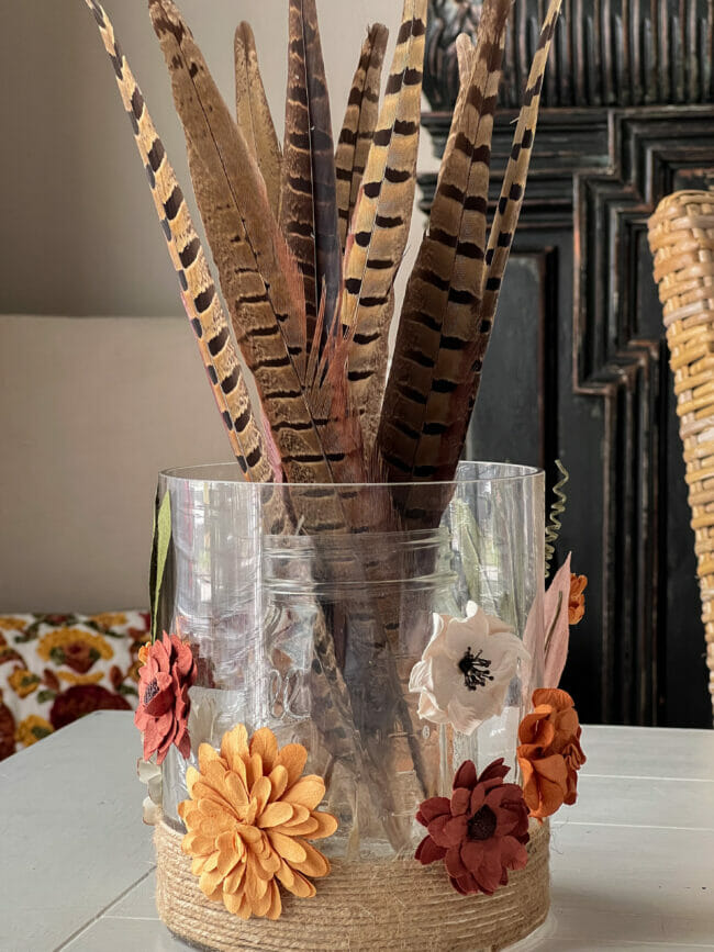 vase with paper flowers on outside and feathers inside