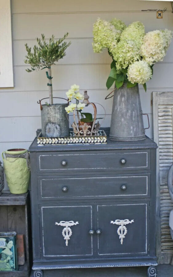 charcoal painted chest with plants and flowers on top