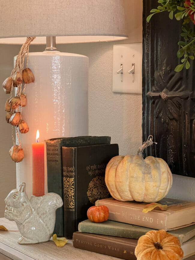 books with squirrel candle holder and gold pumpkin