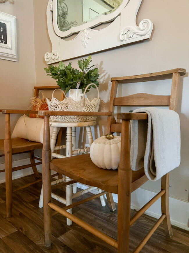 close up of old chair, pumpkin and stool with basket