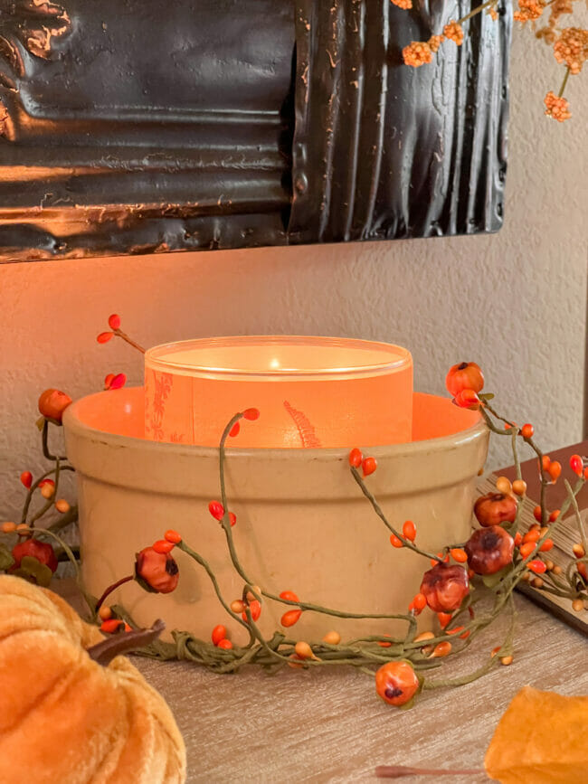 gold crock with candle and pumpkin ring around it