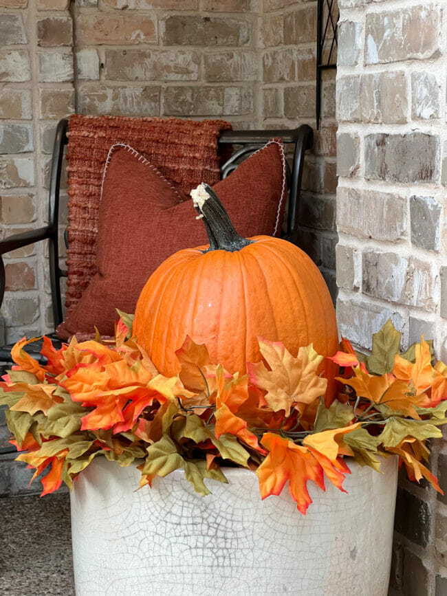 orange pumpkin with garland in white pot