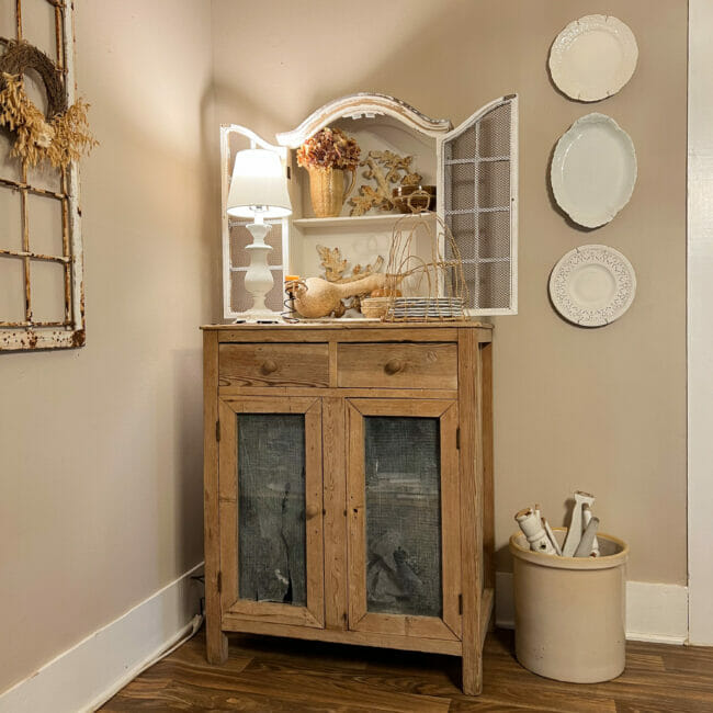 small wood cabinet with smaller white cabinet on top and fall decor with lamp