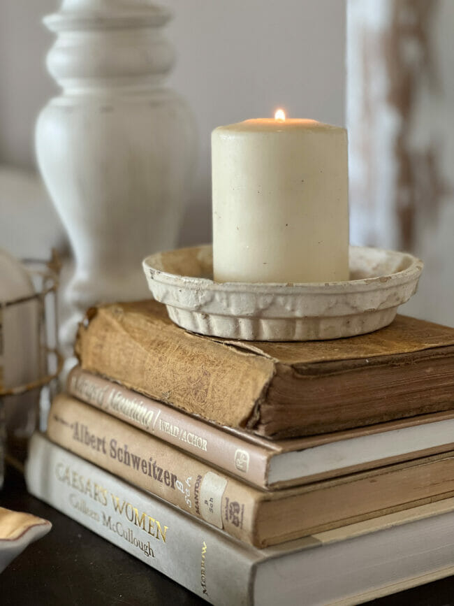 vintage gold books with white candle sitting on top