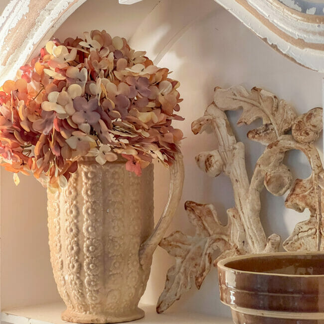 vintage gold pitcher with fall flowers and iron piece with edge of brown bowl