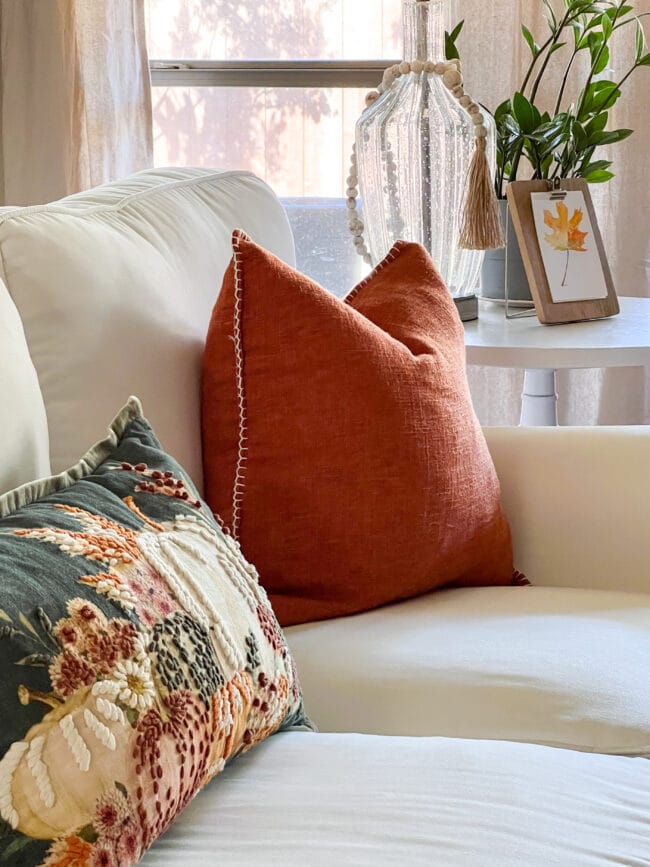 white sofa with rust and green fall pillow