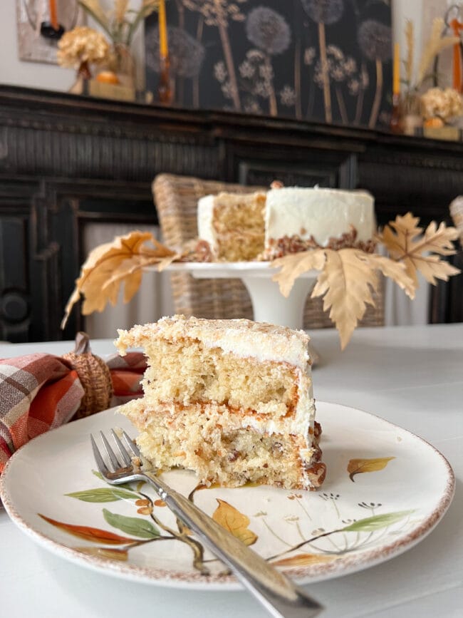 slice of white cake with fork and cake stand in background