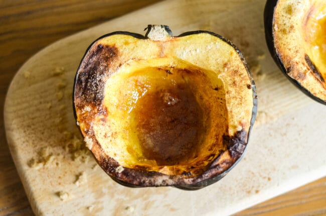 half and open acorn squash on board