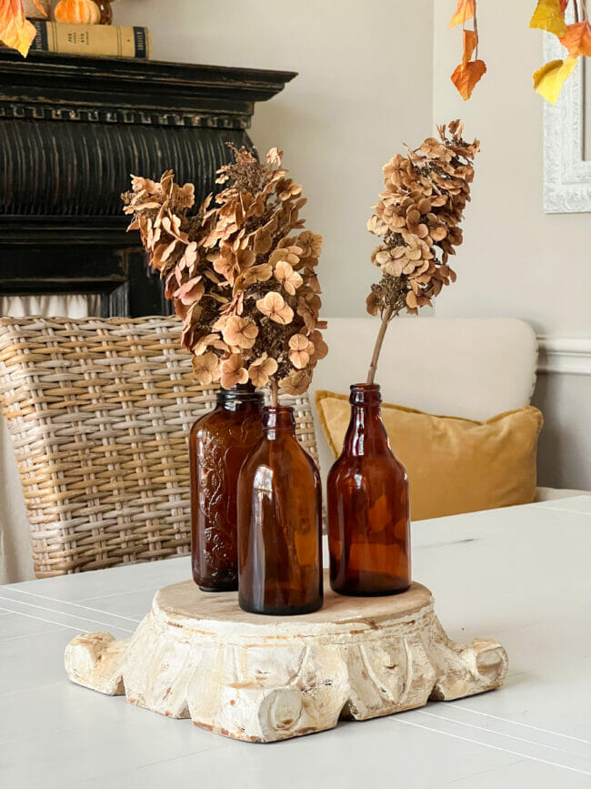 3 amber bottles with dried flowers as a table centerpiece