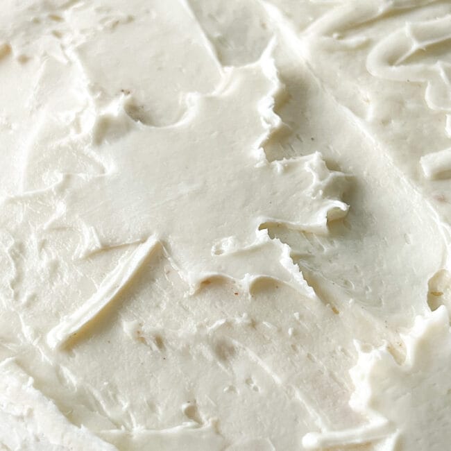 close up shot of a fall leaf in icing on a white cake