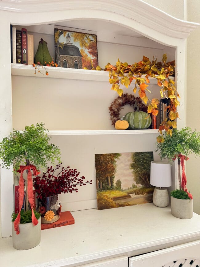shelves with fall stems, painting, books and fall decor
