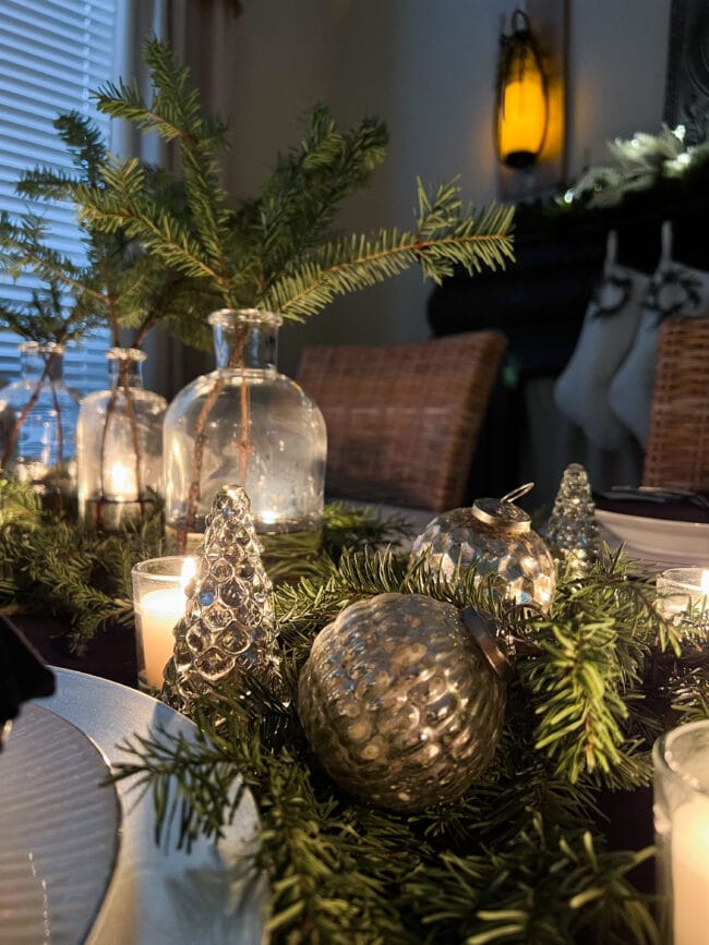 fresh greenery and close up of silver ornaments in a centerpiece