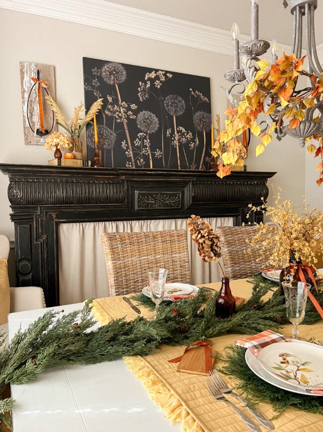 black mantel with fall flowers and a woodsy table setting