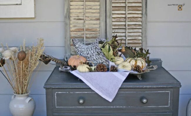 dark cabinet with white cornucopia and gourds