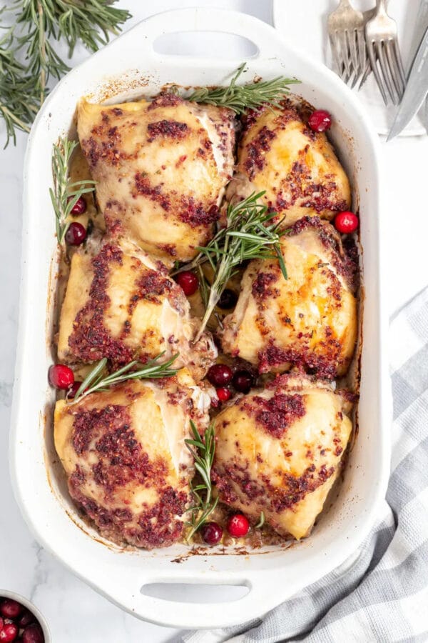 cooked chicken with rosemary and cranberry in white dish