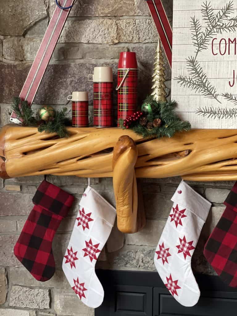 wood mantel with red plaid thermoses and stockings