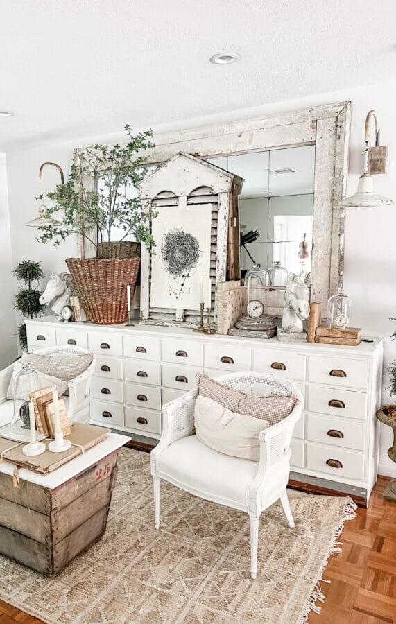 large white cabinet with shite chair, basket coffee table and farmhouse finds in front of a white mirror