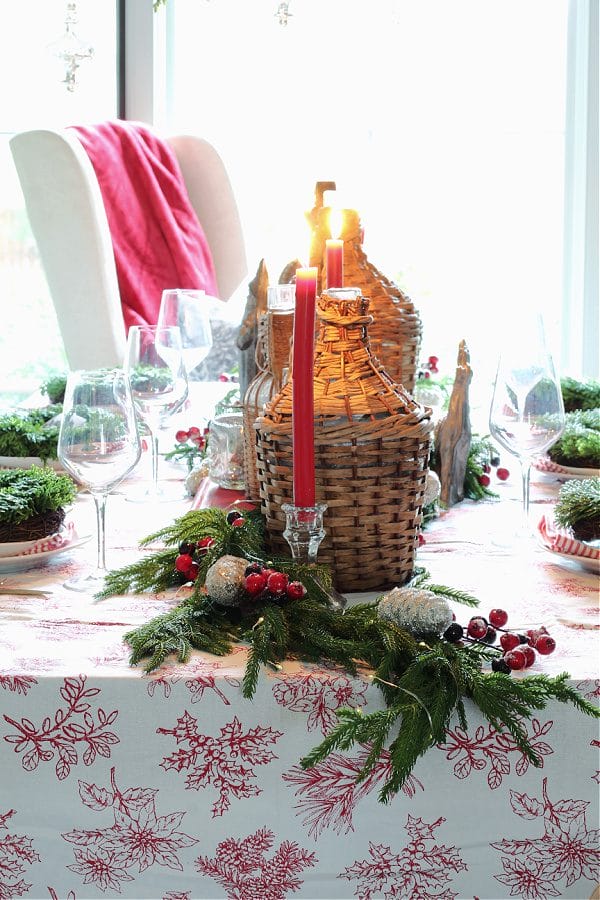 table with wicker demi-johns, garland and red candles
