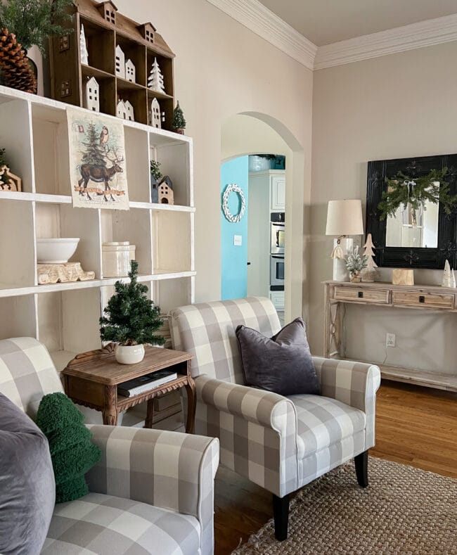 cubby shelf with 2 checked chairs, and console table with black mirror in background