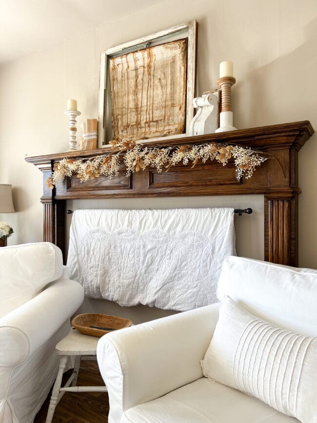 mantel with white quilt hanging underneath and white furniture