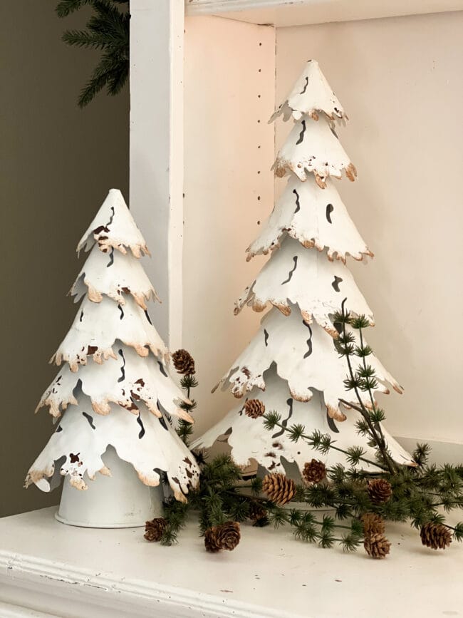 close up of white metal trees with green stems tucked in at bottom