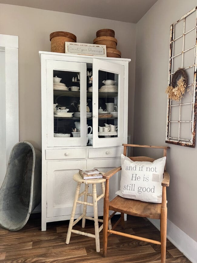 white dining hutch with wood chair with pillow, stool side table and baby bath standing on the side