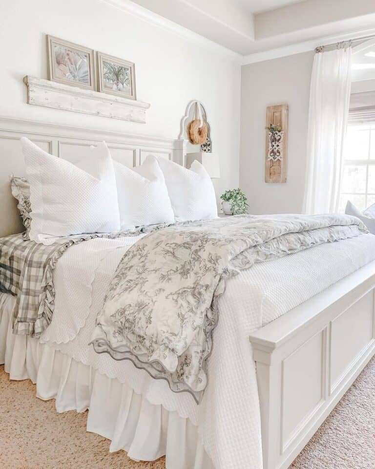 white bed with layers of quilts and a toile comforter