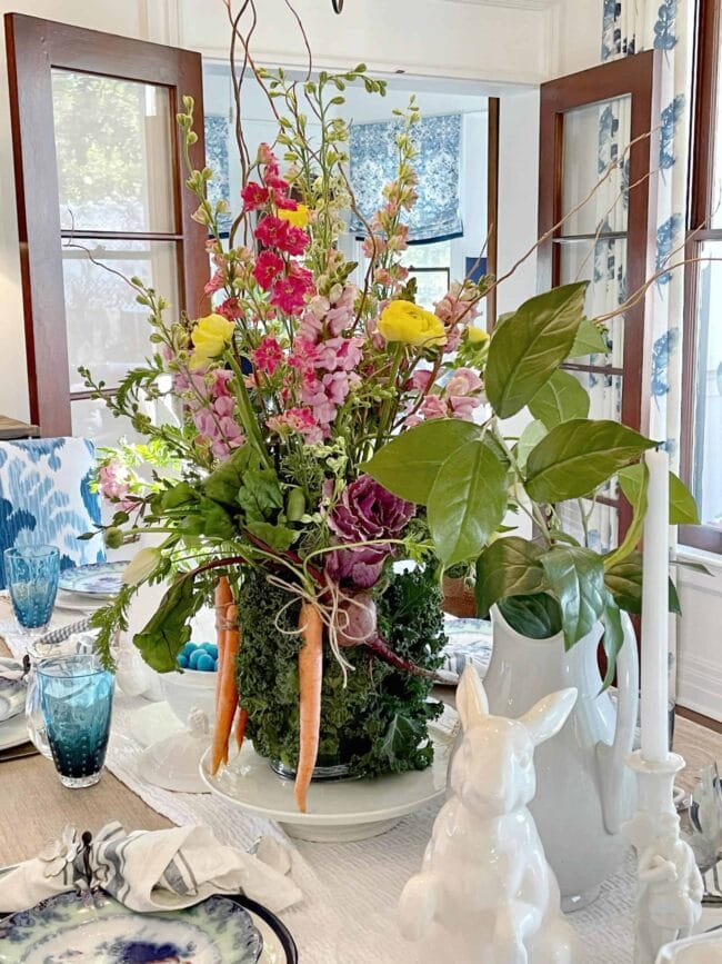 flower arrangement witha cabbage leaf vase, white bunnies and candles