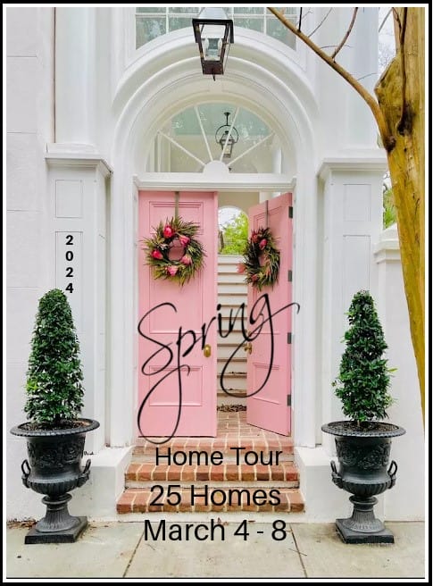 pink front doors with wreaths and topiaries on a white house