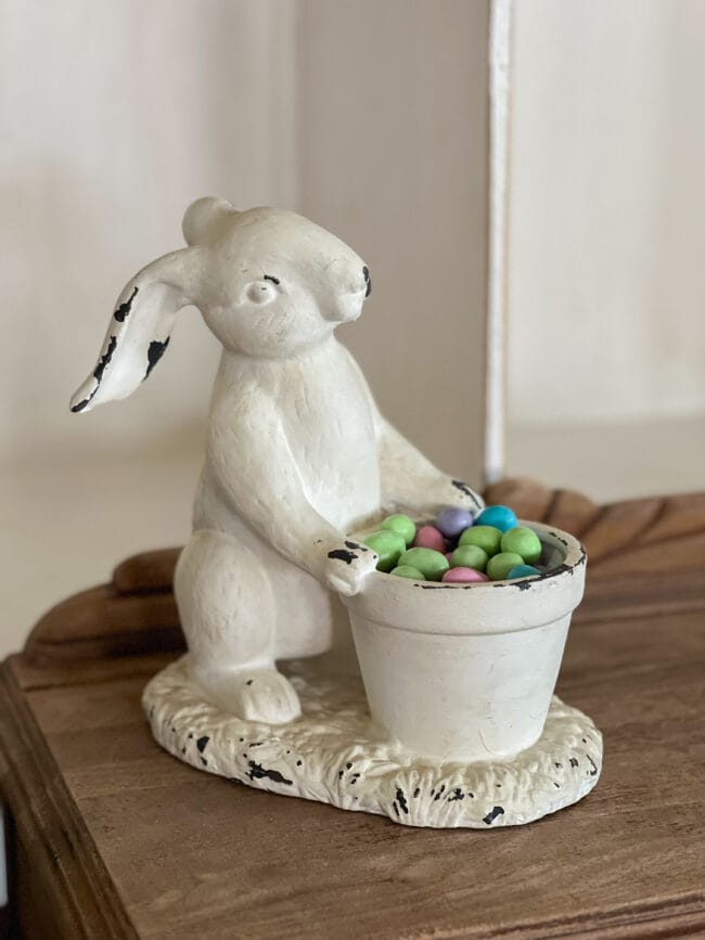 white plaster bunny with Easter egg candy in pot
