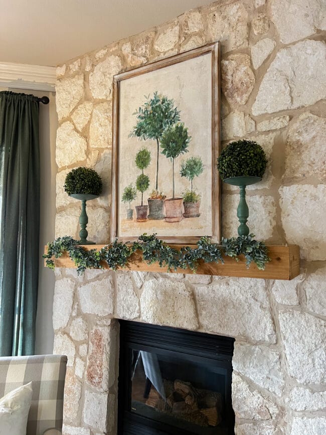 stone mantel fireplace with topiary print and garland