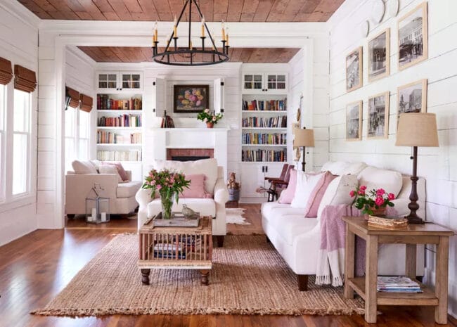 cottagecore living room with jute rug, white sofas, and a wall of books