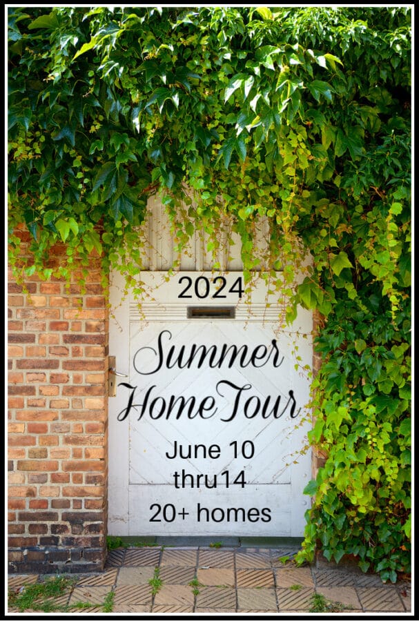 white barn door with brick and an arbor of greenery hanging over the door