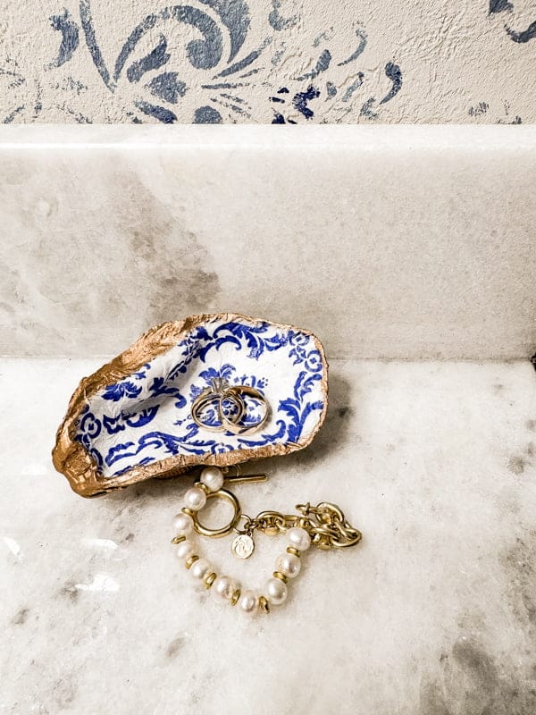 blue, white and gold painted shell with gold jewelry inside